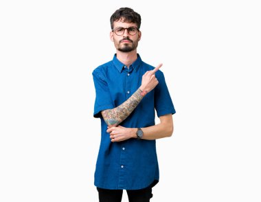 Genç yakışıklı adam gözlük izole üzerinde işaretçi el parmak reklam, ciddi ve sakin yüz gösterilen yan için arka plan