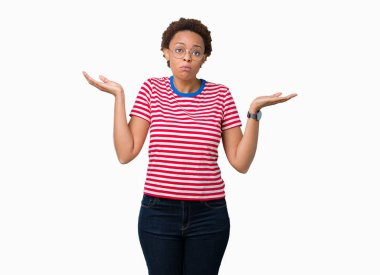 Güzel genç Afro-Amerikan kadın üzerinde gözlük takan arka plan clueless ve şaşkın bir ifadeyle kollar ve eller kaldırdı izole. Şüphe kavramı.