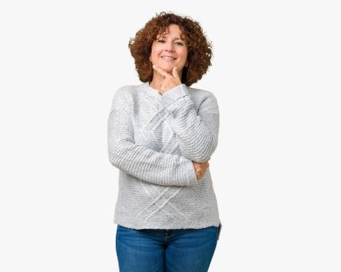 Emin çapraz kollar ve çeneme kaldırdı el ile gülümseme ile kameraya bakarak izole arka plan üzerinde kış kazak giyen güzel orta ager üst düzey kadın. Pozitif düşünce.