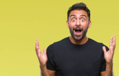 Deli kutluyor ve silah ile başarı için heyecanlı çığlık kaldırdı ve açık gözleri hayret izole arka plan yetişkin İspanyol adam. Kazanan kavramı