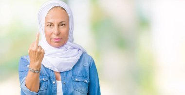 İzole arka plan gösteren orta parmak, kaba ve kaba siktir git ifade üzerinden Arap hijab giyen orta yaş Doğu Arap kadın