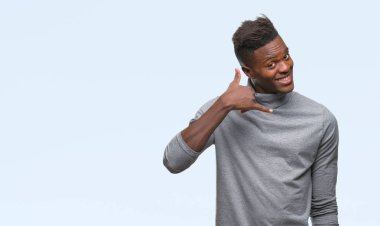 Genç Afro-Amerikan adam yapıyor gülümseyen izole arka plan üzerinde telefon hareketi ile el ve parmak telefonda konuşuyor gibi. Kavramları iletişim.