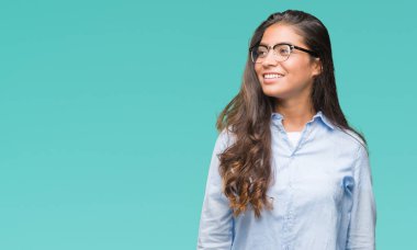 Uzak tarafına yüzünde, doğal ifade gülümseme ile seyir izole arka plan üzerinde gözlük takan genç güzel Arap kadın. Kendine güvenen gülüyor.