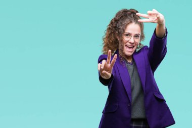 Okul üniforması ve gözlük kamera zafer işareti yapıyor parmak gösteren seyir gülümseyen izole arka plan üzerinde giyen genç esmer öğrenci kız. İki numaralı.