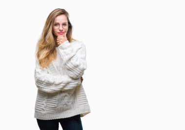 Kış kazak ve güneş gözlüğü izole arka plan emin çapraz kollar ve çeneme kaldırdı el ile gülümseme ile kamera seyir üzerinde giyen genç güzel sarışın kadın. Pozitif düşünce.