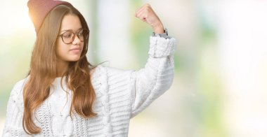 Kış şapka ve gözlük izole arka plan güçlü kişi kol kas, kendinden emin ve güç gurur gösterilen üzerinde giyen genç güzel esmer hipster kadın