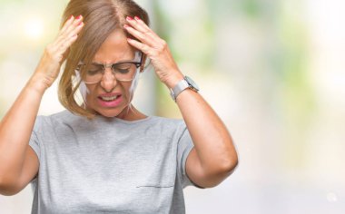 Çünkü çaresiz ve stresli baş ağrısı acı izole arka plan üzerinde gözlük takan orta yaş İspanyol kadın kıdemli ağrı ve migren. Ellerini kafasına.