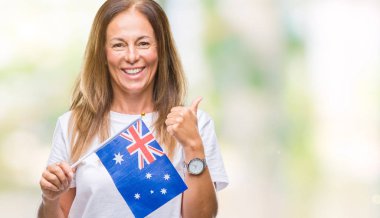 Orta yaş İspanyol kadın holding bayrağı Avustralya izole arka yapıyor ok işareti, kocaman bir gülümseme ile mutlu üzerinde parmak ile mükemmel işareti başparmak