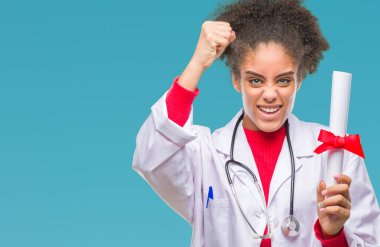 Genç afro Amerikalı doktor kadın holding derecesi izole üzerinde arka plan ile öfke, çılgın ve yükseltilmiş eliyle diye bağıran rahatsız ve hayal kırıklığına uğramış öfke kavramı bağırarak