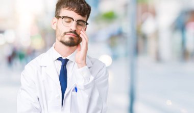 Düşünme izole arka plan bakmaktan beyaz önlük giyen genç profesyonel bilim adam yorgun ve sıkılmış çapraz silah depresyon sorunları ile.