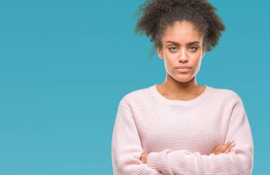 İzole arka plan şüpheci ve sinir, onaylamayan ifade yüz çapraz kolları üzerinde kış kazak giyen genç afro Amerikalı kadın. Negatif kişi.