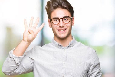 Gösterilen arka plan üzerinde gözlük takan genç yakışıklı adam izole ve parmakları ile işaret kendinden emin ve mutlu gülümseyerek süre dört numara.