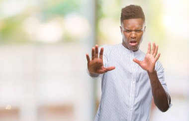 Şokta bağırarak genç Afro-Amerikan adam izole arka plan korkuyor ve korku ifade dur hareketi el ile ile çok korkmuş. Panik kavramı.