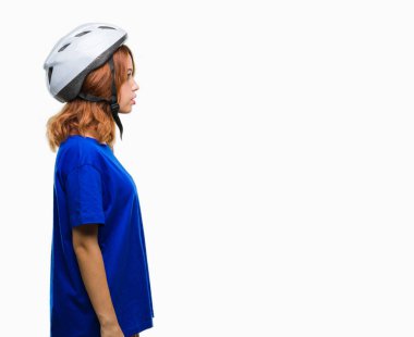 Genç güzel kadın giyiyor bisikletçi kask izole arka tarafına, seyir üzerinde dinlenmek doğal yüz emin gülümseme ile pozuyla profili.