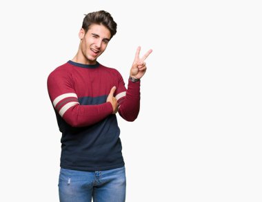 Mutlu yüz zafer işareti yaparken kameraya göz kırpıyor ile gülümseyen izole arka plan üzerinde genç yakışıklı adam. İki numaralı.