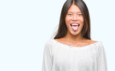 Genç Asyalı kadın dilini izole arka plan üzerinde out komik ifade ile mutlu. Duygu kavramı.