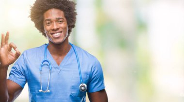 Afro Amerikalı cerrah doktor adam izole arka plan el ve parmaklar ok işaretiyle yapıyor olumlu gülümseyen üzerinde. Başarılı ifade.
