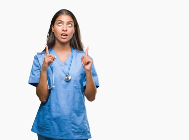 Genç Arap Doktor cerrah kadın izole arka plan üzerinden hayran ve yukarıya bakıp parmakları ile işaret şaşırttı ve silah kaldırdı.