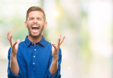 Genç yakışıklı adam izole arka plan çılgın ve kızgın bağırarak ve agresif ifade ve silah kaldırdı bağırıyor. Hayal kırıklığı kavramı.