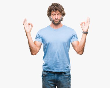 Yakışıklı İspanyol modeli adam izole arka plan üzerinde dinlenmek ve gülümseyen gözlerle parmak ile meditasyon jest yapıyor kapalı. Yoga kavramı.
