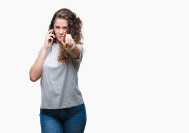 Genç esmer kız Smartphone'da konuşmayı kamera ve size parmak ile işaret arka plan izole, el işareti, pozitif ve kendinden emin bir jest ön