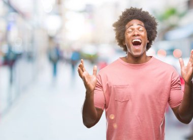 Afro Amerikalı adam kızgın ve silah ile başarı için deli kutluyor izole arka plan üzerinde kaldırdı ve heyecanlı çığlık gözler kapalı. Kazanan kavramı