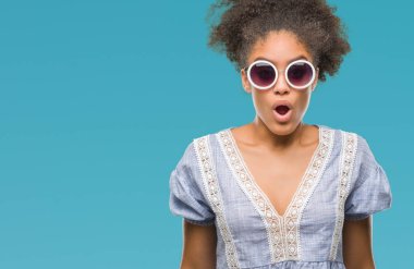 Korkuyor ve şok sürpriz ifade, korku ve heyecan yüz ile izole arka plan üzerinde gözlük takan genç afro Amerikalı kadın.
