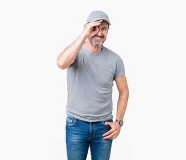 Yakışıklı orta yaş ağarmış komuta sizde gülümseyen, parmakları ile mutlu yüz üzerinden seyir göz el ile ok jest yapıyor izole arka plan üzerinde spor şapkası.