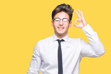 İzole arka plan el ve parmaklar ok işaretiyle yapıyor olumlu gülümseyen üzerinde gözlük takan genç iş adamı. Başarılı ifade.