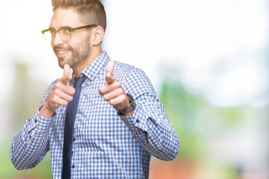 Fotoğraf makinesi ile mutlu ve komik yüz için parmakları işaret izole arka plan üzerinde gözlük takan genç iş adamı. İyi enerji ve vibes.