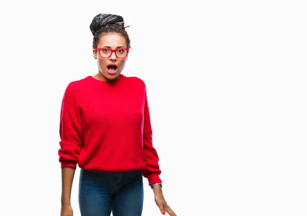 年轻的编织头发非洲裔美国女孩穿着毛衣和眼镜在孤立的背景害怕和震惊与惊喜的表情 恐惧和兴奋的脸 — 图库照片