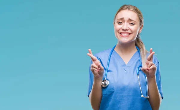 Młoda Blondynka Chirurg Lekarz Kobieta Białym Tle Uśmiechnięty Palców Przejściach — Zdjęcie stockowe