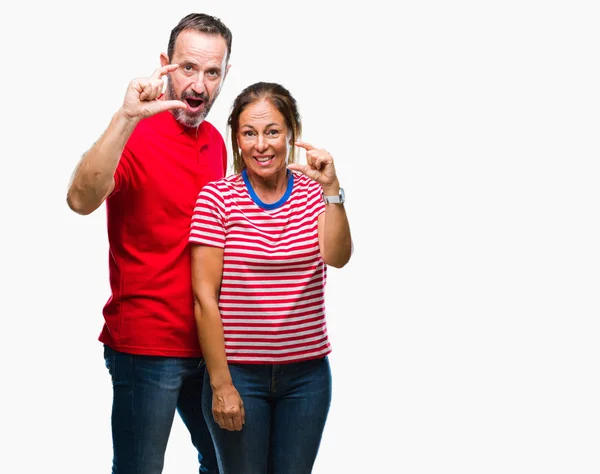中年西班牙夫妇在爱在孤立的背景微笑和自信的手势与手做大小标志与手指 而看和相机 测量概念 — 图库照片