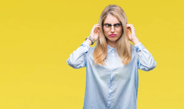 若い美しい金髪のビジネス女性が眼鏡をかけて大声で音楽の音の腹が立つ式の指で耳を覆う孤立した背景の上 聴覚障害者の概念 — ストック写真