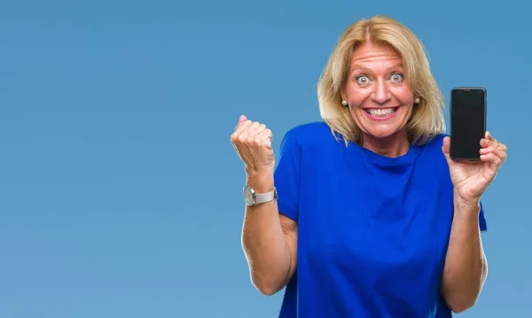 stock image Middle age blonde woman showing blank screen of smartphone over isolated background screaming proud and celebrating victory and success very excited, cheering emotion