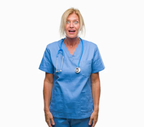 驚きの表現 恐怖と興奮した顔でショックを受けた分離の背景以上の中年ブロンドの看護師外科医医師女性 — ストック写真
