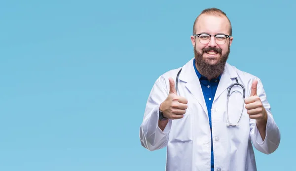 年轻的高加索医生男子穿着医疗白色外套在孤立的背景 批准做积极的手势与手 竖起大拇指微笑 并为成功高兴 看着镜头 赢家的手势 — 图库照片
