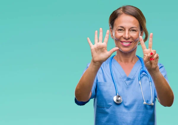中年资深护士医生妇女在孤立的背景显示和指向手指数字七 而微笑着自信和快乐 — 图库照片