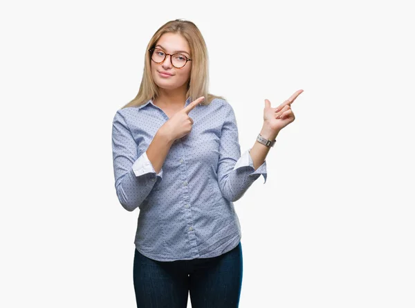 眼鏡をかけて笑顔で側に つの手と指で指しているカメラを見て孤立の背景に若い白人ビジネス女性 — ストック写真