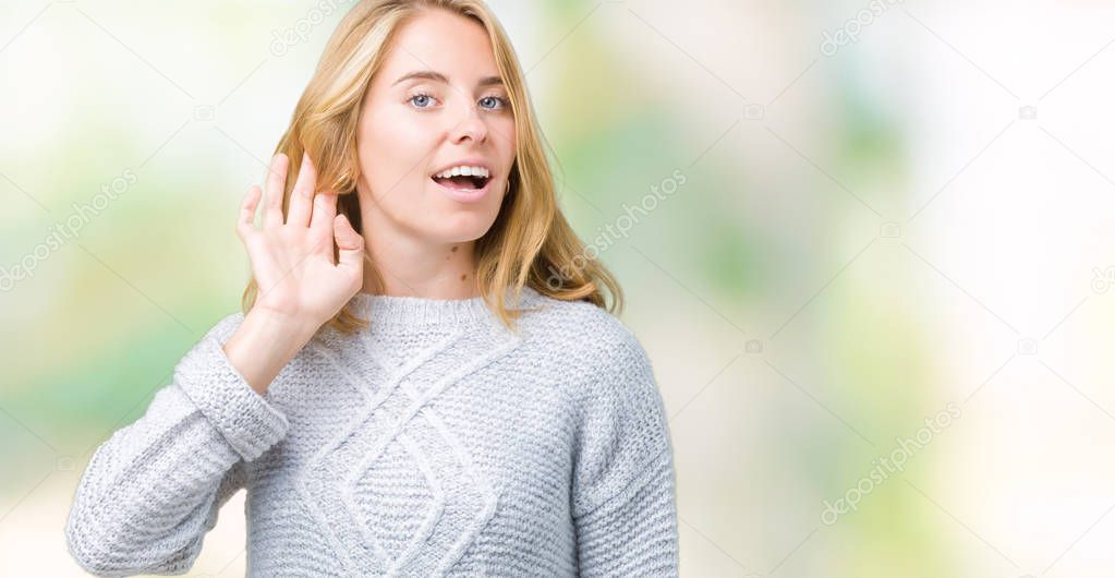 Beautiful young woman wearing winter sweater over isolated background smiling with hand over ear listening an hearing to rumor or gossip. Deafness concept.