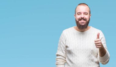 Hareketi el ile mutlu yaşasın yapıyor izole arka plan üzerinde kış kazak giyen genç beyaz hipster adam. Kameraya bakarak başarı gösteren ile ifade onaylama.