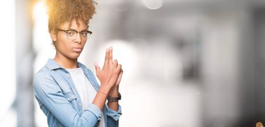 Güzel genç Afro-Amerikan kadın el hareketi ile sembolik silah tutan, çekim silah, kızgın yüz öldürmek oynamaya izole arka plan üzerinde gözlük