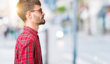 Genç yakışıklı adam gözlük izole arka tarafına, seyir üzerinde dinlenmek doğal yüz emin gülümseme ile pozuyla profili.