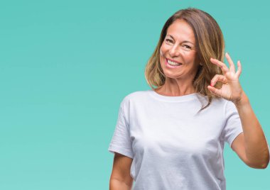 Gülümseyen izole arka plan üzerinde orta yaş İspanyol kadın kıdemli el ve parmaklar ok işaretiyle yapıyor olumlu. Başarılı ifade.