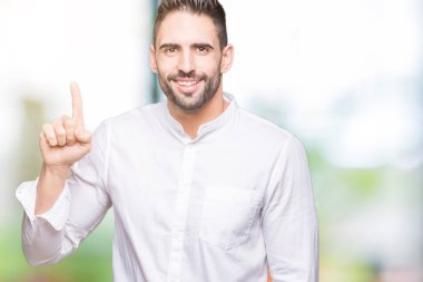 Genç iş adamı ve parmak gülümseyen süre bir numara ile kendinden emin ve mutlu yukarıyı gösteren izole arka plan üzerinde.