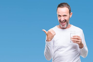 Orta yaş ağarmış komuta sizde işaret ve başparmak kadar mutlu yüz gülümseyen tarafı ile gösteren izole arka plan üzerinde bardak su içme