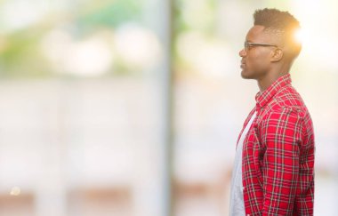 İzole arka tarafına, arayan genç Afro-Amerikan adam sakin ol kendine güvenen gülümseme ile doğal yüz pozuyla profili.