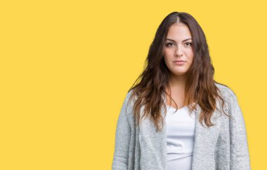 Artı boyutu genç kadın güzel kış ceket üzerinde arka plan gevşek yüzünde ciddi bir ifade ile izole. Basit ve doğal kameraya bakıyor.