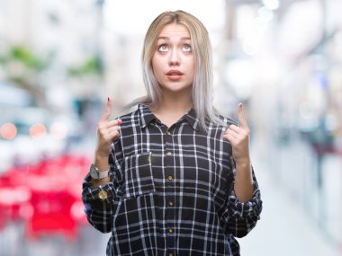 Sarışın genç kadın izole arka plan üzerinden hayran ve yukarıya bakıp parmakları ile işaret şaşırttı ve silah kaldırdı.