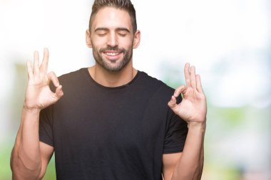 Yakışıklı delikanlı izole arka plan üzerinde dinlenmek ve gülümseyen gözlerle parmak ile meditasyon jest yapıyor kapalı. Yoga kavramı.